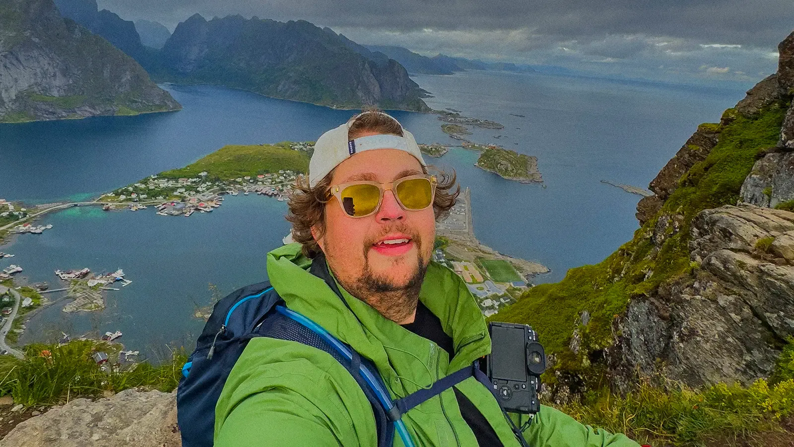 Josh Smith on a mountain above a fjord